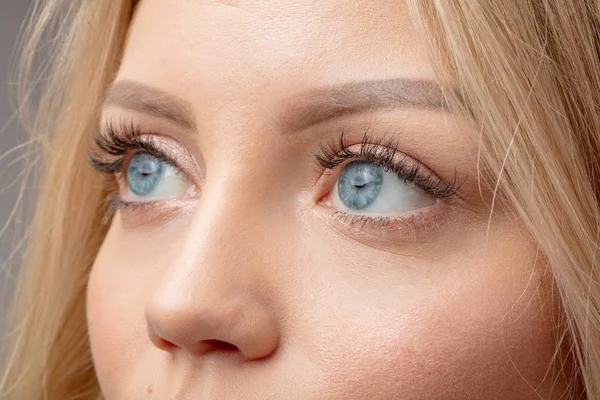 Schöne Blondine mit wunderschönen blauen Augen — Stockfoto