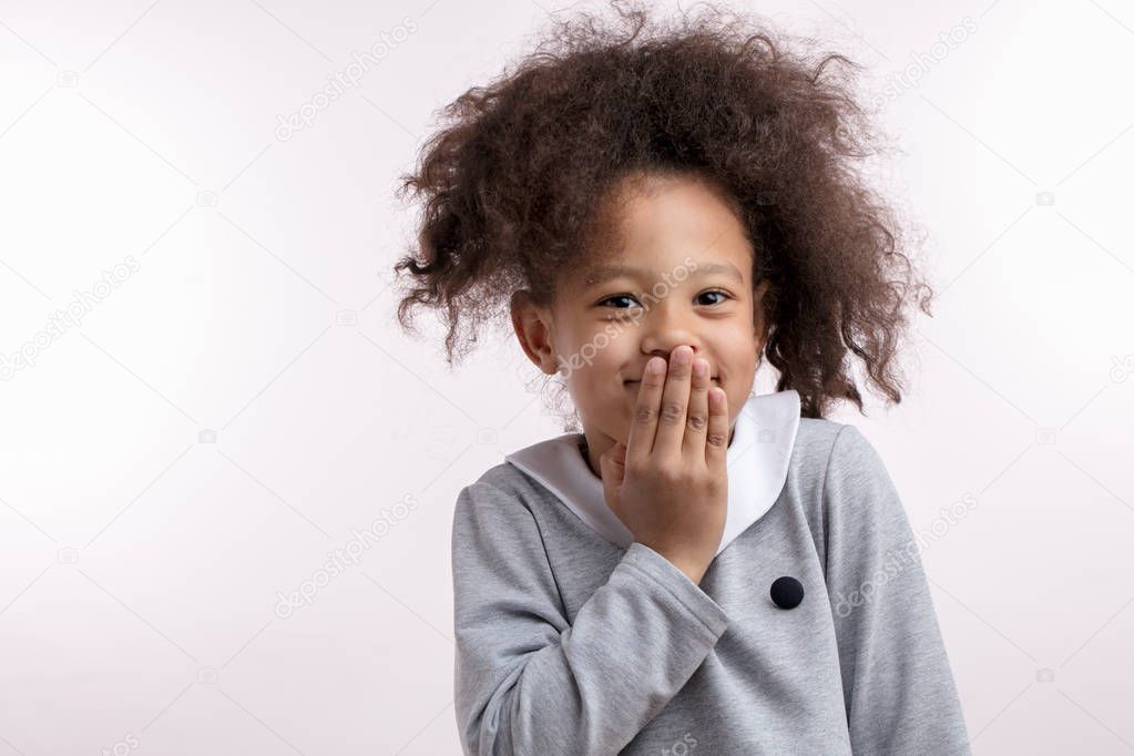 giggling afro child with funny ponitail looking at the camera