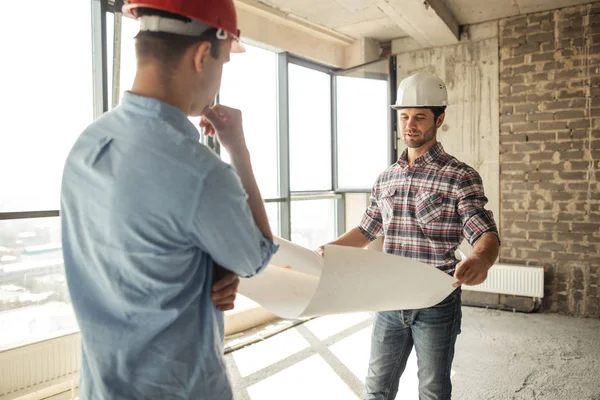 Führungspersönlichkeit im roten Helm kontrolliert die Ingenieursarbeit — Stockfoto