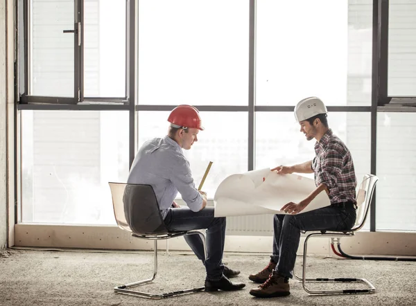 Foto in voller Länge. zwei Ingenieure, die Breite und Länge des Gebäudes zählen — Stockfoto