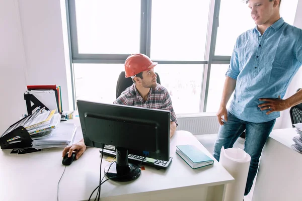 Büroangestellte gibt einem Architekten Anweisungen — Stockfoto