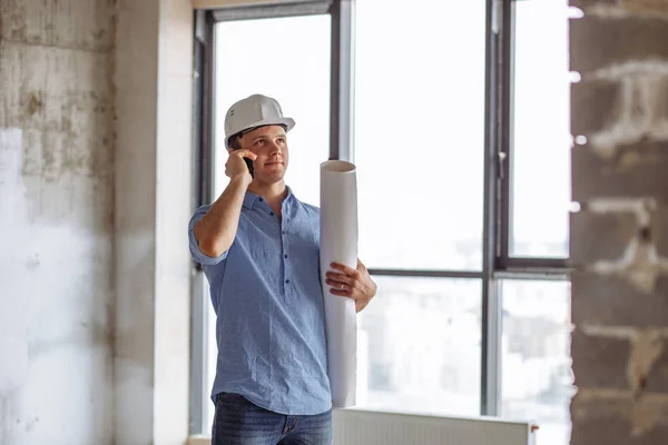 Engenheiro positivo está falando no telefone inteligente — Fotografia de Stock