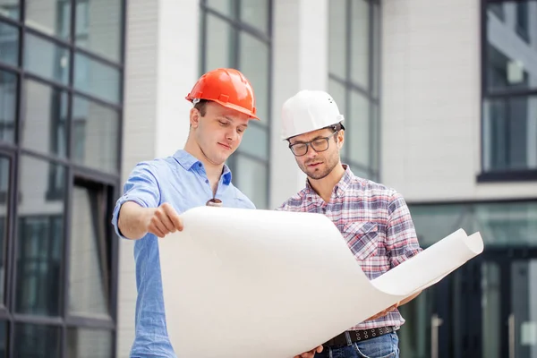 Zwei fleißige Bauarbeiter analysieren das Projekt — Stockfoto