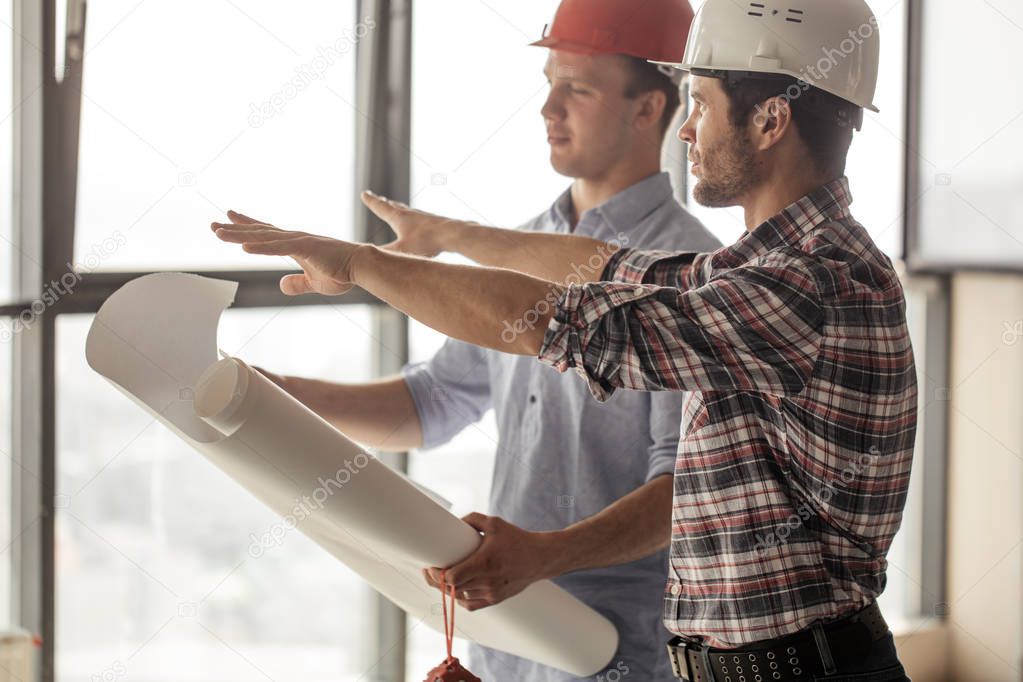 architect is pointing at building place to the customer