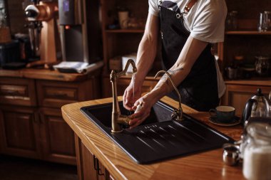 Genç garson mutfak kafede elinde yıkama portresi