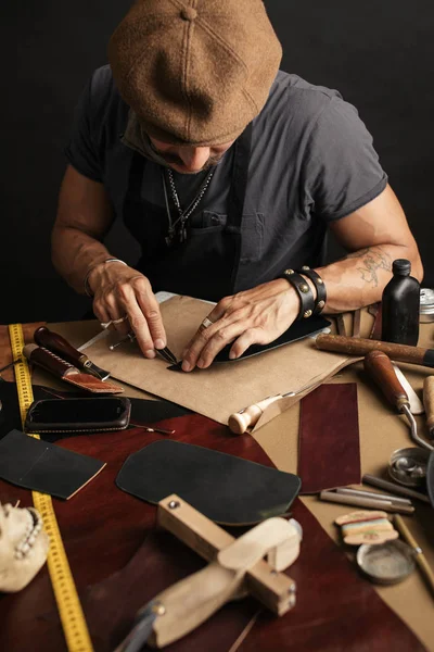 Cordonnier Whiskered avec faire des mesures dans les motifs à la table dans l'atelier — Photo