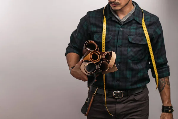 Artesã de couro em chapéu preto criativo posando com artigos de couro no estúdio . — Fotografia de Stock