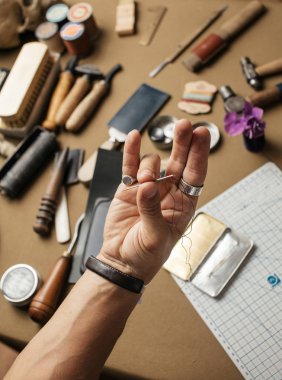 Deri atölyesinde el yapımı deri cüzdan üretme süreci.