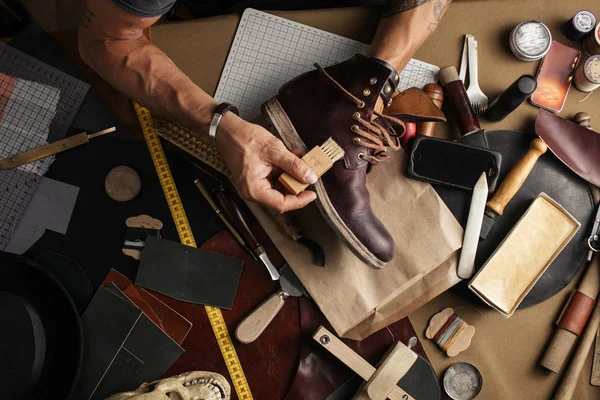 Ayakkabı imalatçısının ellerinde deri atölyesinde çizme üretirken. — Stok fotoğraf