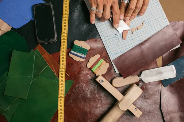 Close up of a shoemaker working with leather textile and hammer at a workshop — Stock Photo, Image