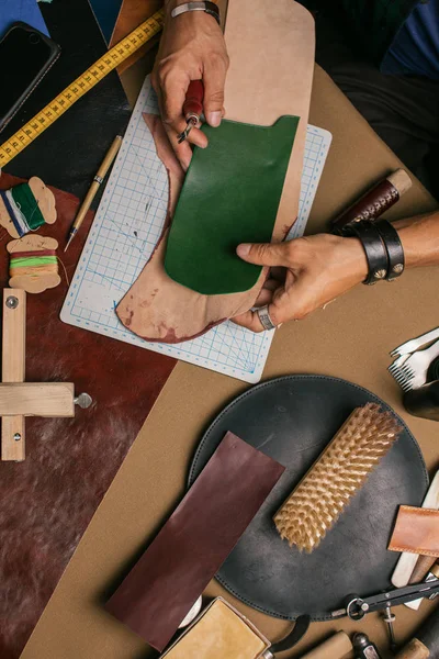 Close up de um sapateiro trabalhando com couro têxtil e martelo em uma oficina — Fotografia de Stock