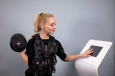 Genç uygun güzel onun kol dumbbell ile Ems makinede turing kadındır