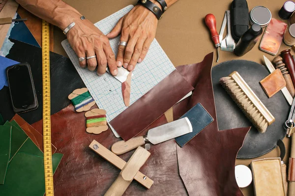 Yakın plan. Bıçakla deri ürünlerine doğranmış bir erkek el ustası. Küçük işletme