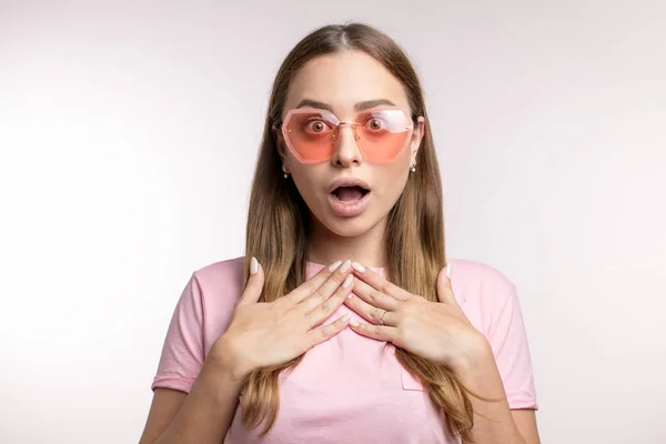 Junge attraktive Frau mit stylischer Sonnenbrille schaut überrascht in die Kamera — Stockfoto