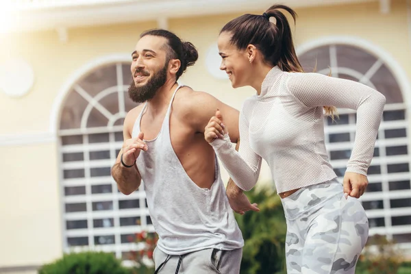 Ejecutar entrenamiento en pareja al aire libre ejercitarse contra el gimnasio. — Foto de Stock
