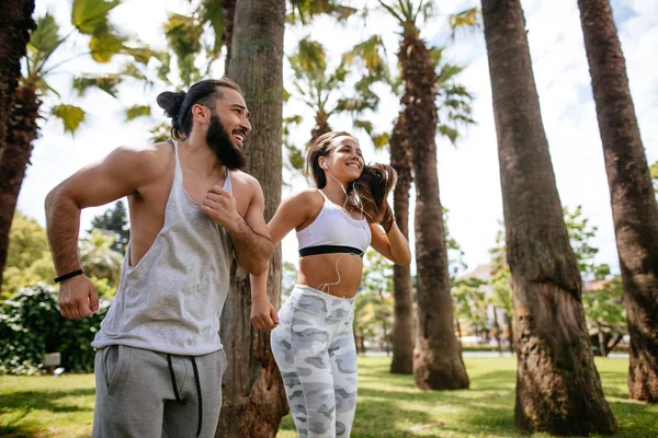 Pareja joven corriendo en el parque en la mañana de verano — Foto de Stock