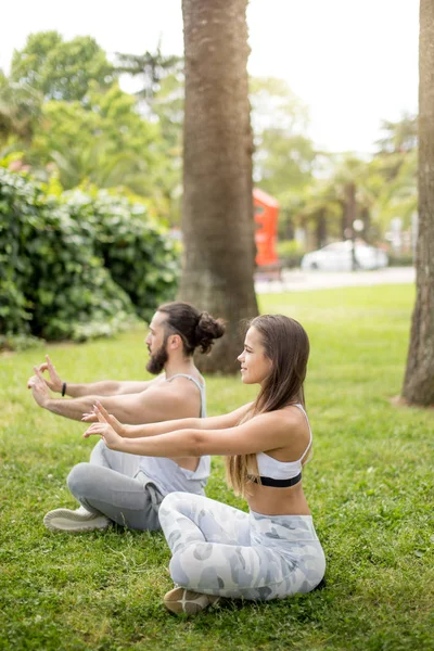 Jong stel doet yoga buiten — Stockfoto