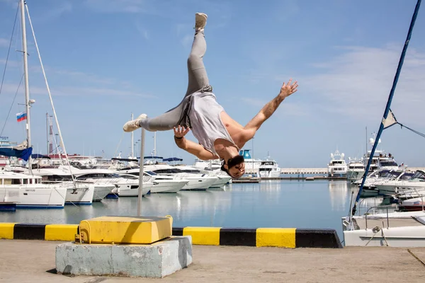 Atleta de fitness fazendo agachamentos de salto em plyo-box improvisado no cais do mar de verão — Fotografia de Stock