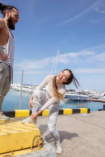 Genç sportif çift antrenman arasında mola veriyor, iskelede koşmaya hazırlanıyor..