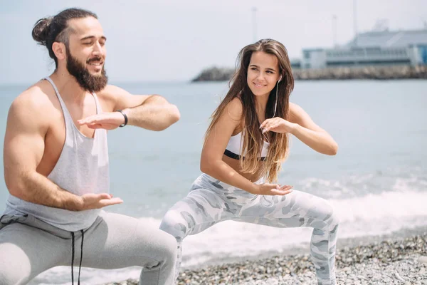 Dışarıda ısınan çiftler, birlikte çömelme hareketleri yapıyorlar.