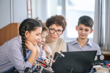 Mutlu çocuklar ders dışı derslerde dizüstü bilgisayar kullanarak programlama öğrenirler.