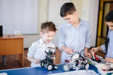 Robot sergisini ziyaret ederken çocuklar elektrikli robotla oynuyorlar
