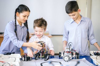 Robot sergisini ziyaret ederken çocuklar elektrikli robotla oynuyorlar