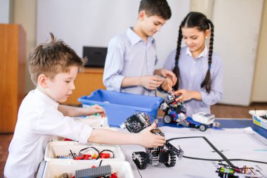 Robot sergisini ziyaret ederken çocuklar elektrikli robotla oynuyorlar