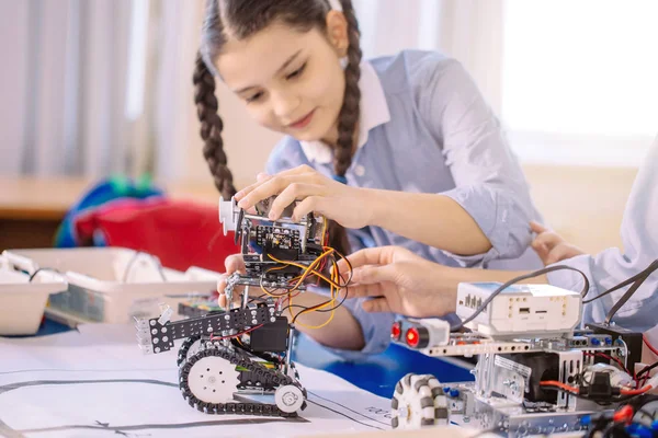 Concentrated caucasian girl creating technical toy — Stock Photo, Image