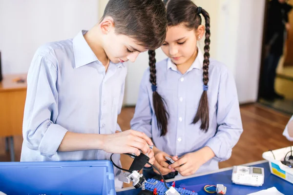 Двоє дітей, брат із сестрою, які беруть участь у своїх іграшках роботів, що конструюють хобі — стокове фото
