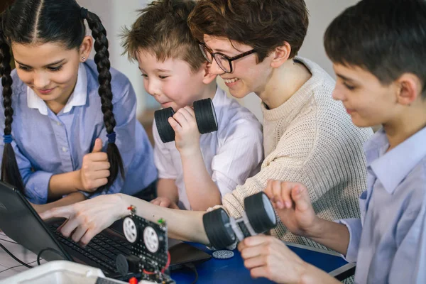 Happy children learn programming using laptops on extracurricular classes