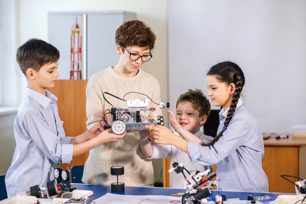 Happy children learn programming using laptops on extracurricular classes