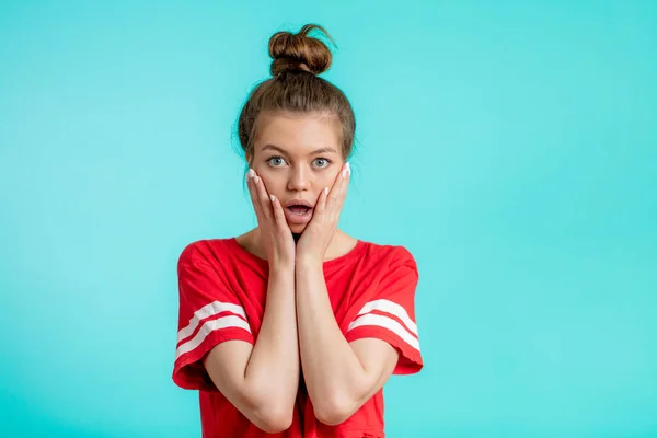 Close-up portret jonge geschokt en verbijsterd vrouw met hairbun en mond opende — Stockfoto