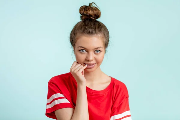 Bonita jovencita sosteniendo su dedo en una boca y mirando a la cámara — Foto de Stock