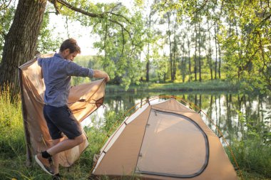 Yakışıklı delikanlı bir çadır kurmak koyuyor