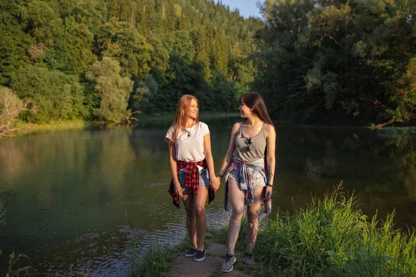 Dvě dívky pozitivní bokovky spočívají na nádhernou krajinu — Stock fotografie
