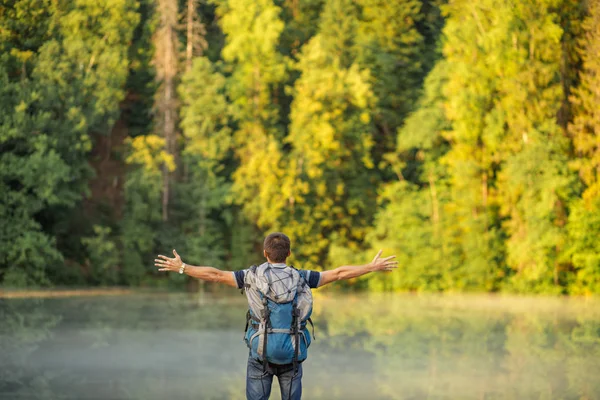 Безтурботний турист з простягнутими руками, що стоять на горах — стокове фото