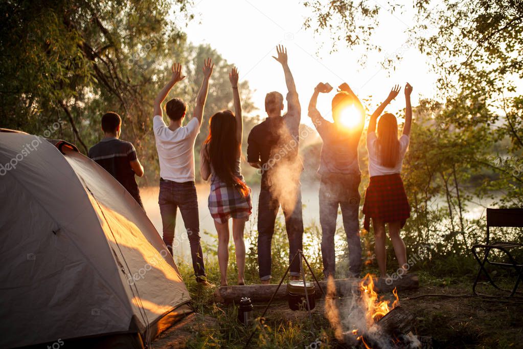 young cheerful tourists admires with gorgeous sunset