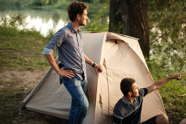 Camping, concepto de turismo. chico guapo está señalando con el dedo a algo — Foto de Stock