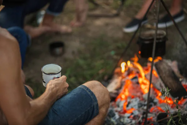 Bijgesneden foto man zit met thee in de buurt van het vuur — Stockfoto