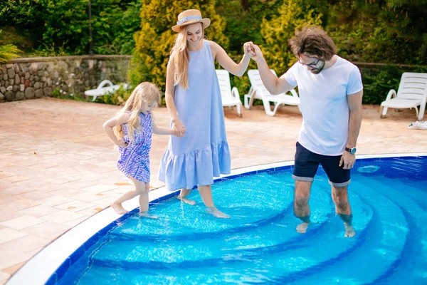Férias em família no verão. Pais com criança se divertindo perto da piscina — Fotografia de Stock
