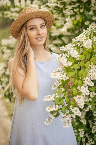 Chica con sombrero amarillo. Mujer joven mirando a la cámara en el campo borroso verano — Foto de Stock
