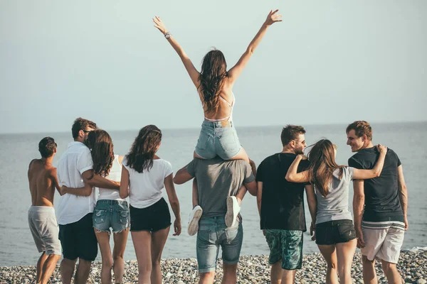 Hombres y mujeres felices caminan en la playa Grupo de amigos disfrutando de vacaciones en la playa —  Fotos de Stock