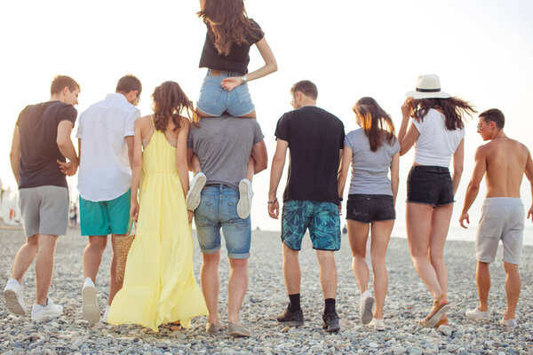 happy mans and womans walk at the beach Group of friends enjoying beach holidays