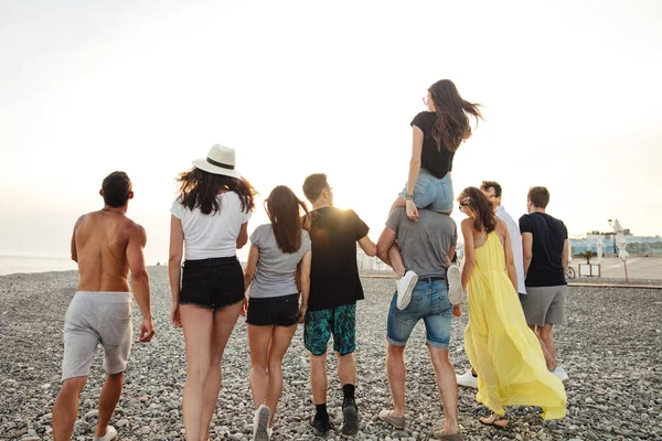 Hombres y mujeres felices caminan en la playa Grupo de amigos disfrutando de vacaciones en la playa — Foto de Stock