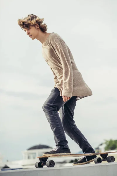 Garçon chevauchant longboard sur boardwalk, heure d "été chaude — Photo