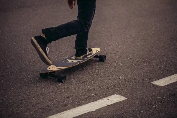 Bijgesneden mannelijke tiener skateboarden in stad met een voet geplaatst aan boord — Stockfoto