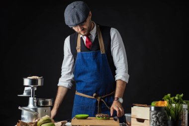 Biftek, salata ve sebzeli yeşil burger pişiren adam..