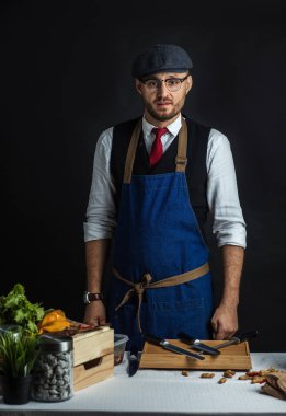 Restoran Şefi, siyah arkaplanda kameraya özgüvenle bakıyor..