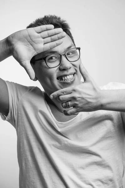 Happy funny Asian man in his 30s in white usual t-shirt with different positive emotions — Stock Photo, Image